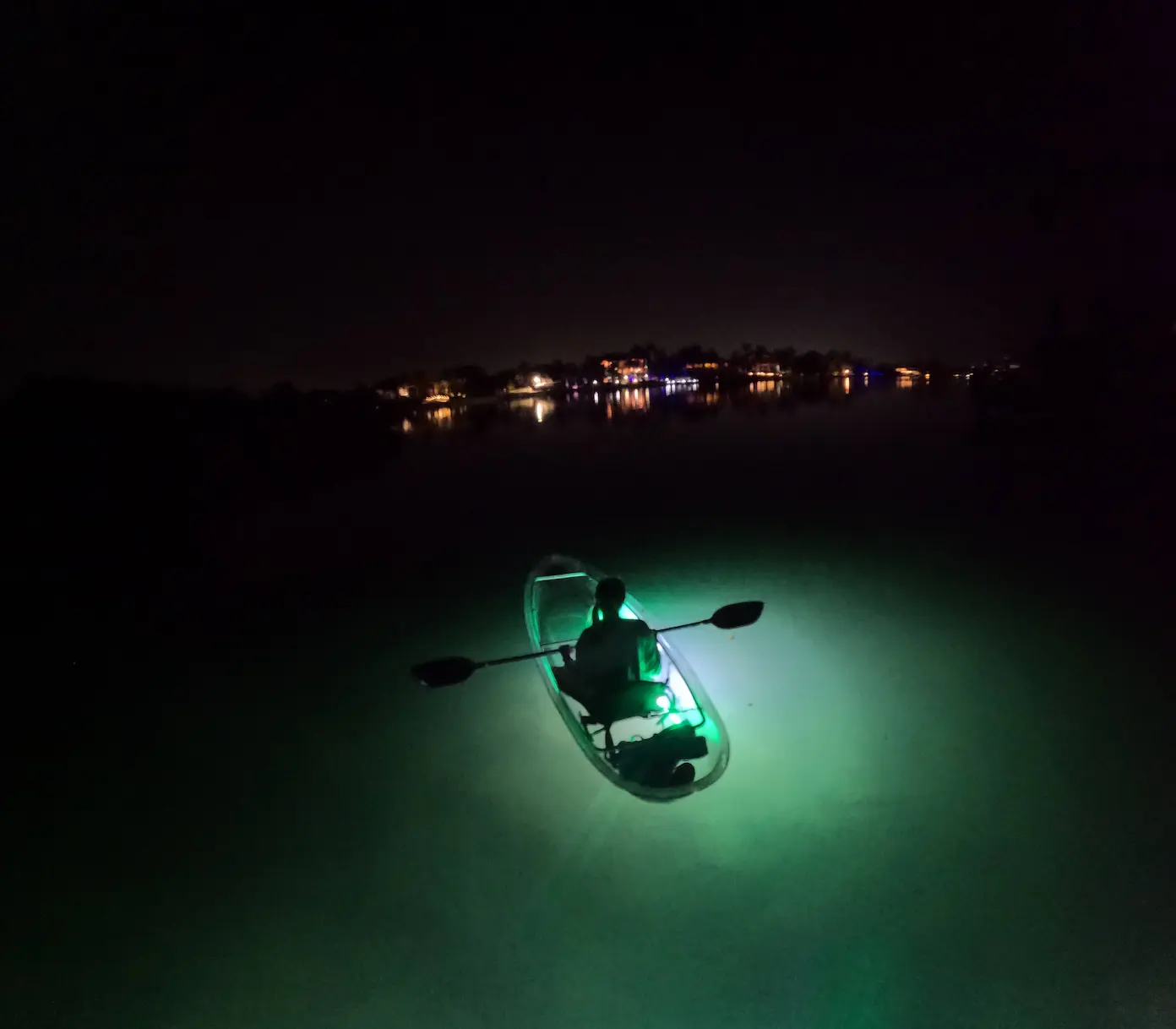 LED lights illuminating underwater from clear kayak