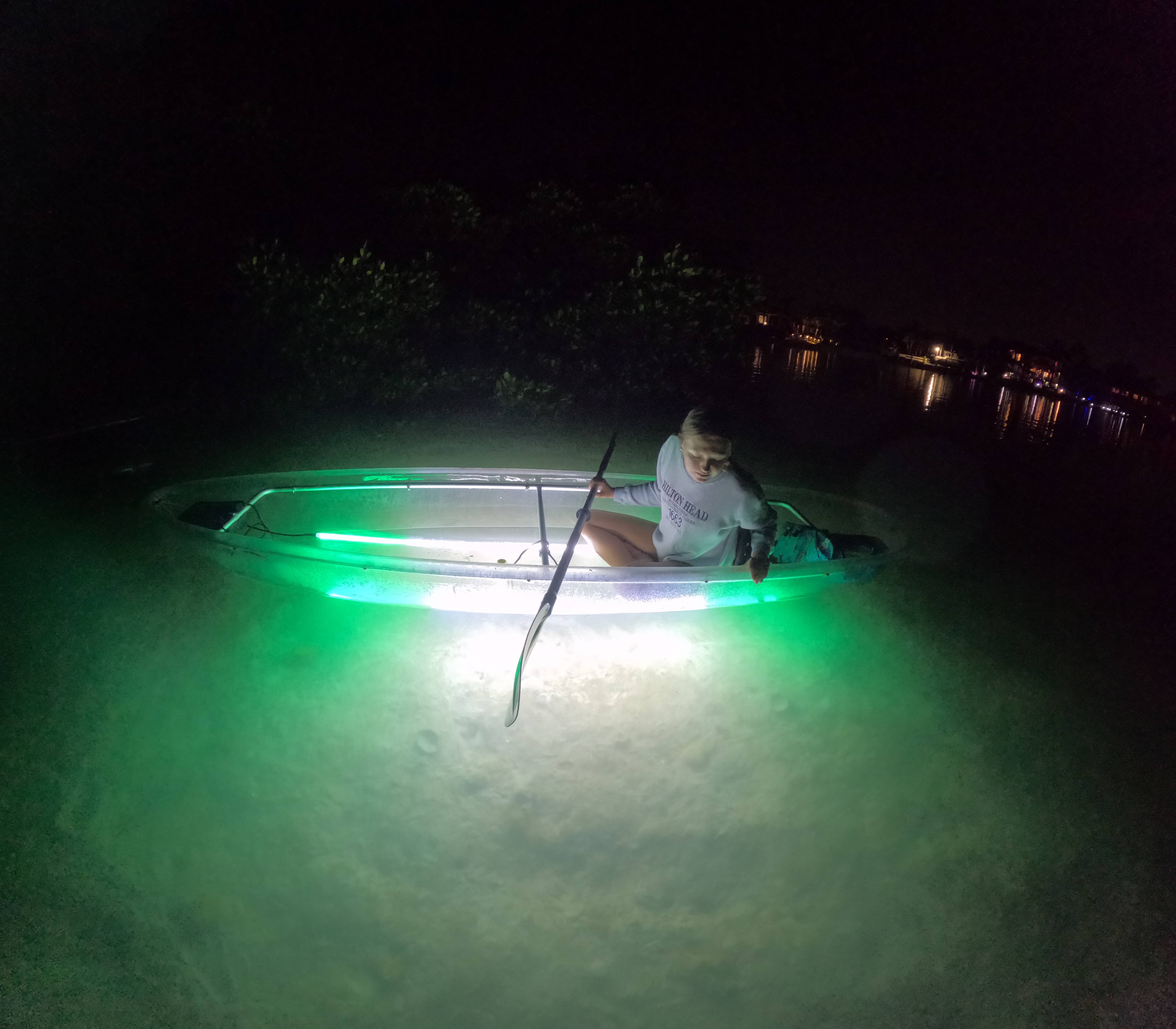 LED illuminated clear kayak night tours in Florida with glowing kayaks on dark water
