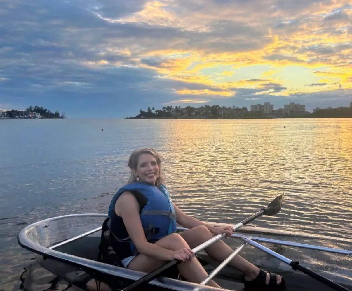Paddlers in clear kayaks watching the sunset from a calm Sarasota lagoon